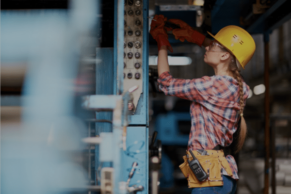 Femme ouvrière travaille sur une machine industrielle.