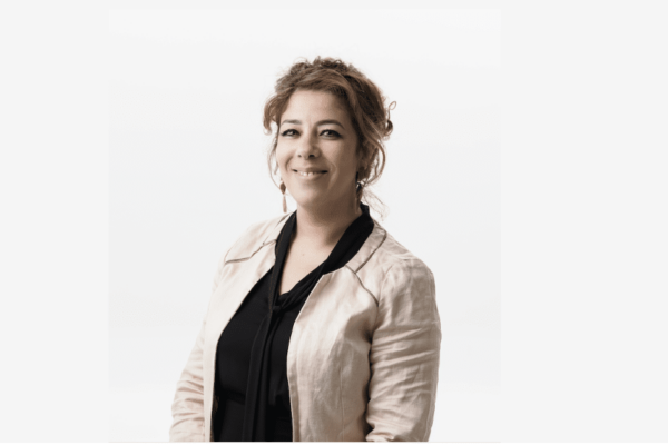 Femme souriante en veste claire.